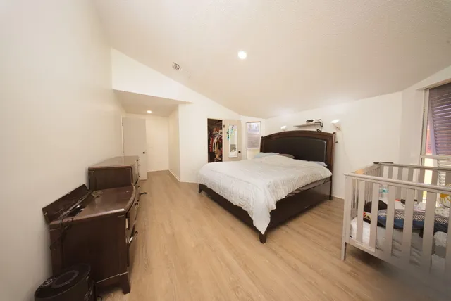 a bedroom with a bed and wooden floor