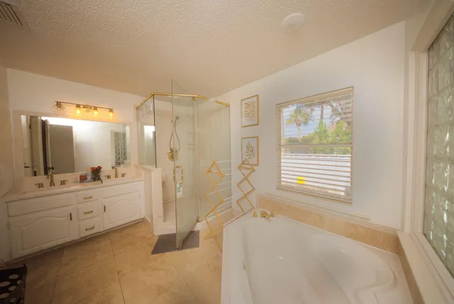 a spacious bathroom with a tub sink a mirror and a shower