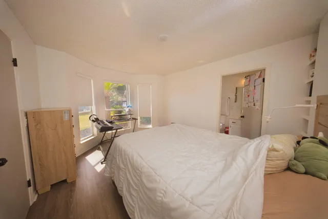 a bedroom with a bed and wooden floor