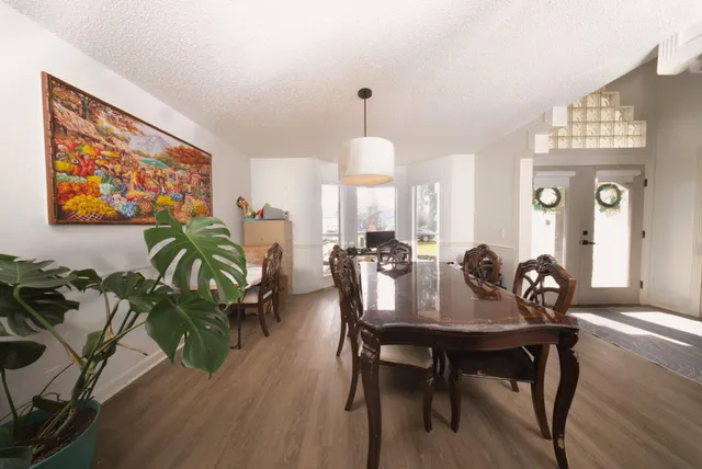 a view of a a dining room with furniture window and wooden floor