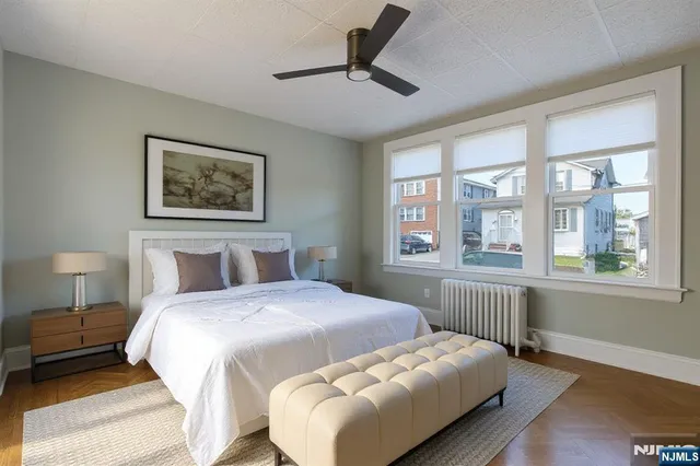 a bedroom with a bed and a large window