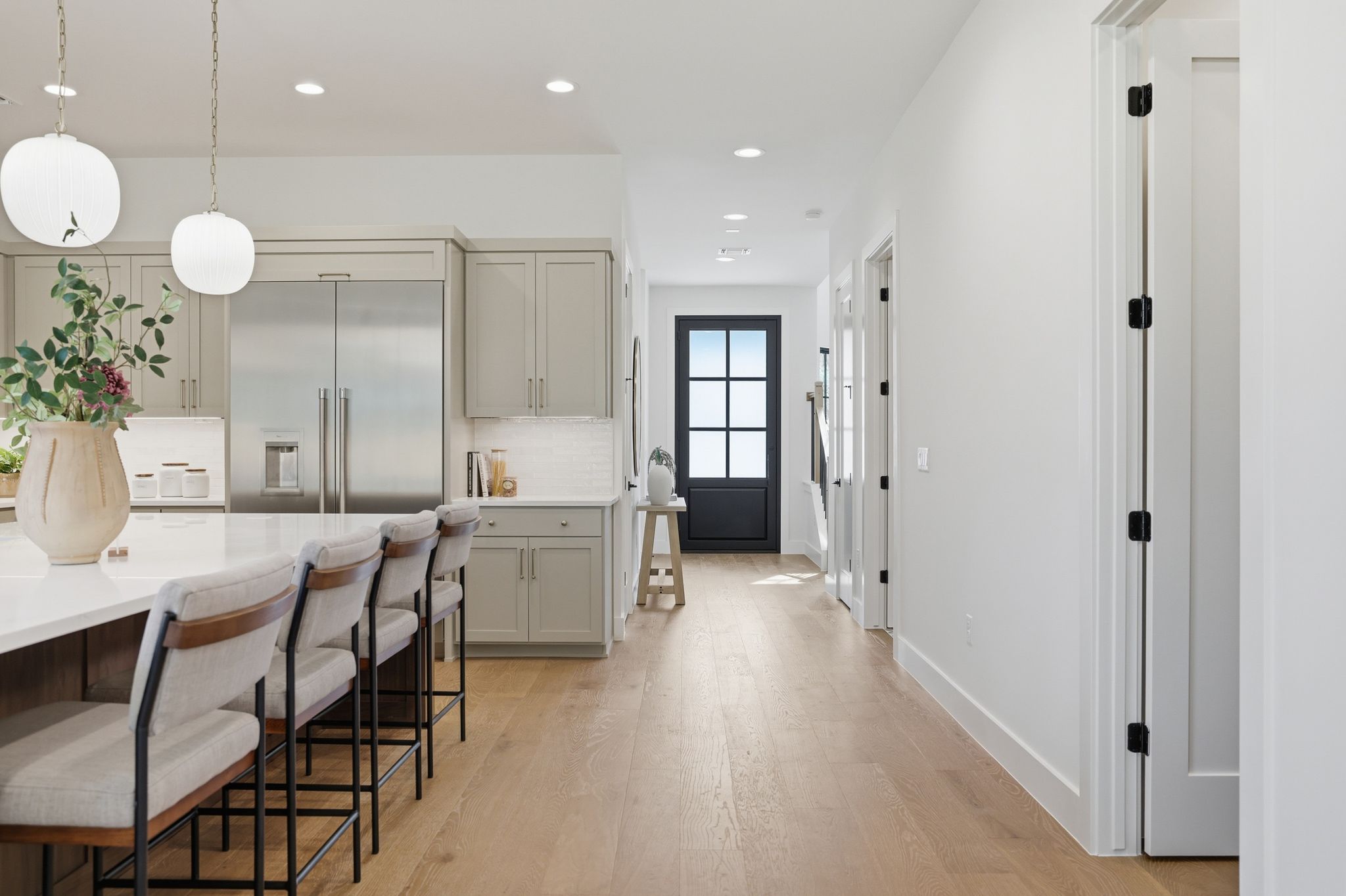 4500 Jinx Avenue Austin, TX 78745 - Photo 16 of 40 Kitchen featuring light wood-style floors, stainless steel built in fridge, a breakfast bar, decorative light fixtures, and decorative backsplash