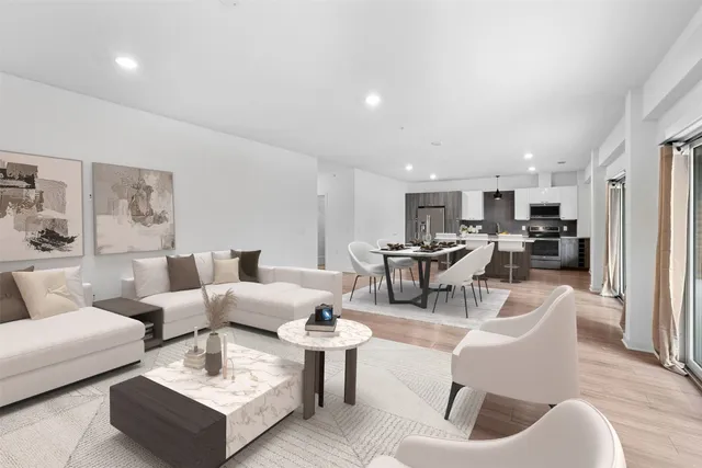a living room with furniture and a view of kitchen