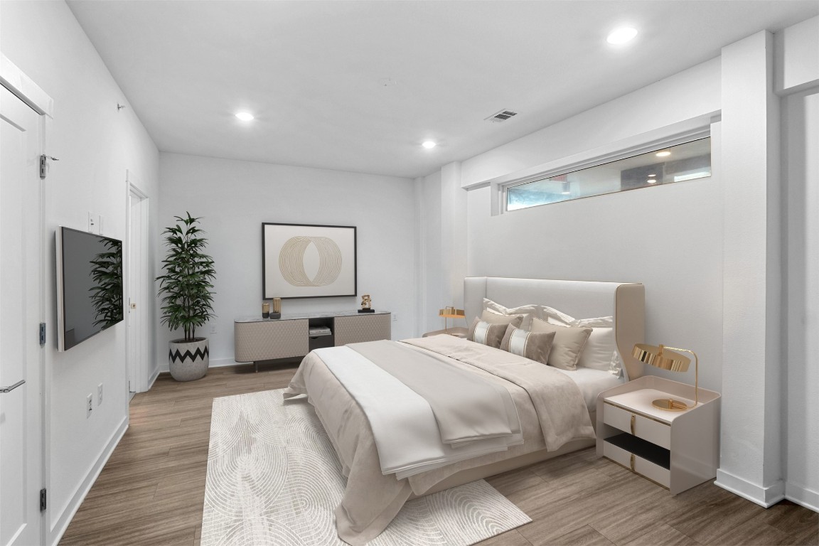 4361 South Congress Avenue, Unit 333 Austin, TX 78745 - Photo 15 of 40 a bedroom with a bed and wooden floor