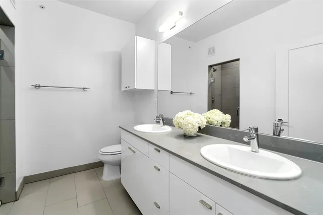 a bathroom with a granite countertop toilet sink and mirror