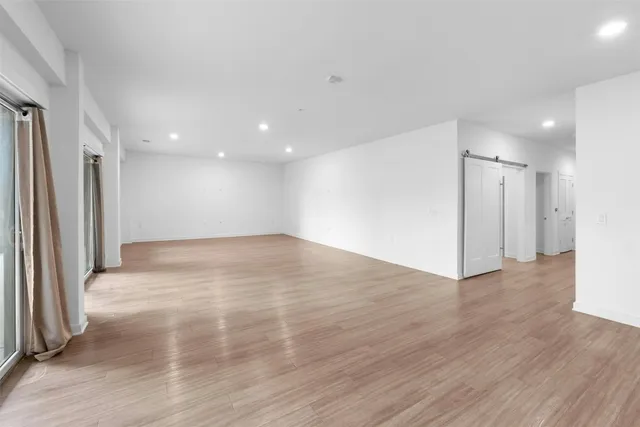 an empty room with wooden floor and a window