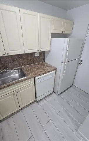 a utility room with cabinets washer and dryer