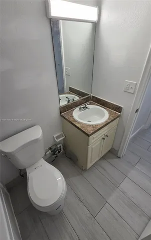 a bathroom with a sink a toilet and mirror