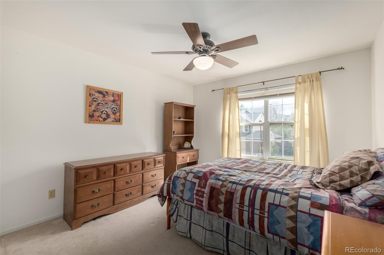 707 Huntington Place Highlands Ranch, CO 80126 - Photo 25 of 50 a bedroom with a bed a dresser and a window