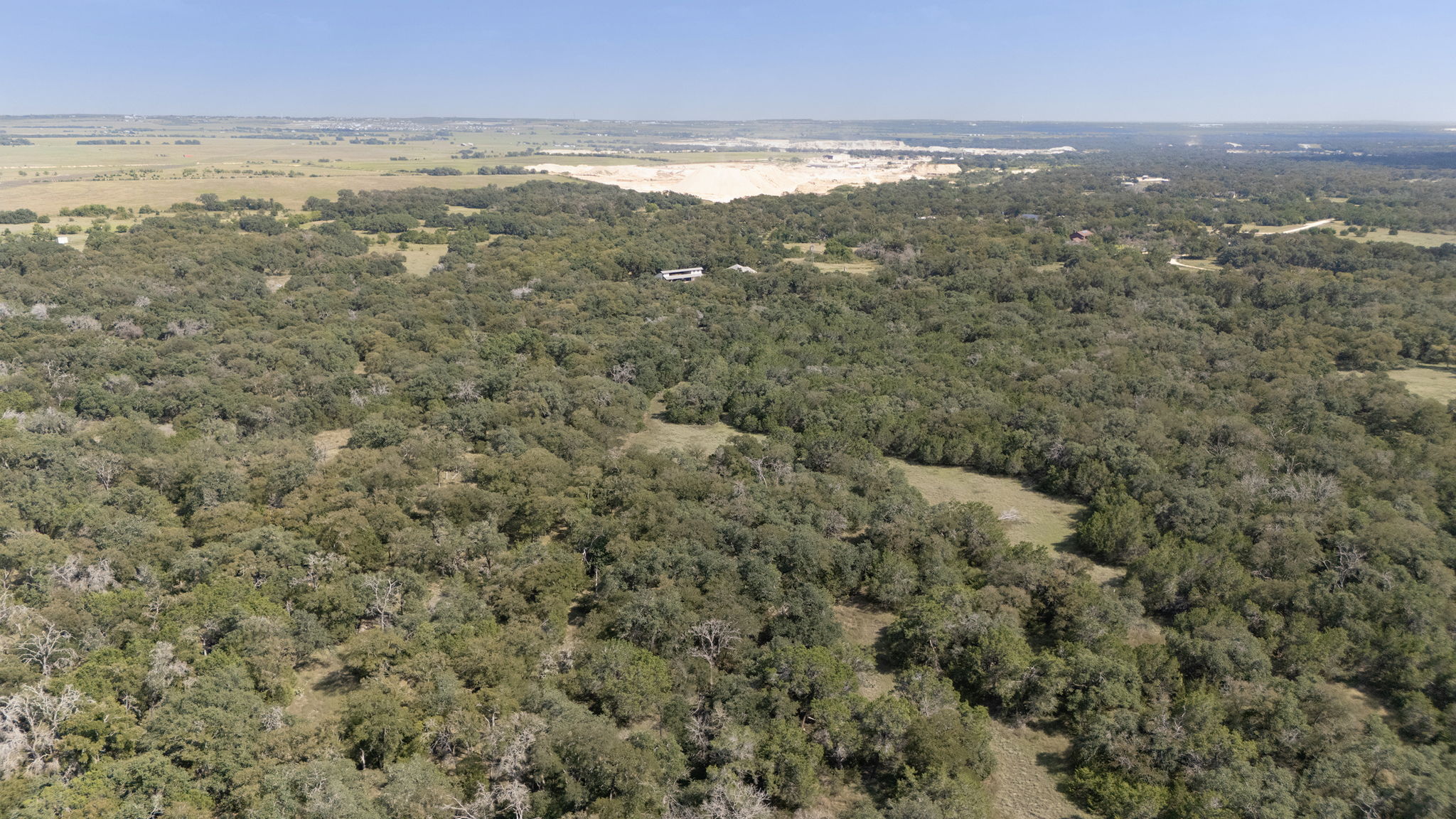 0 Cr 239 Road Georgetown, TX 78633 - Photo 13 of 16 Mature trees blanket the rolling landscape under a clear sky.