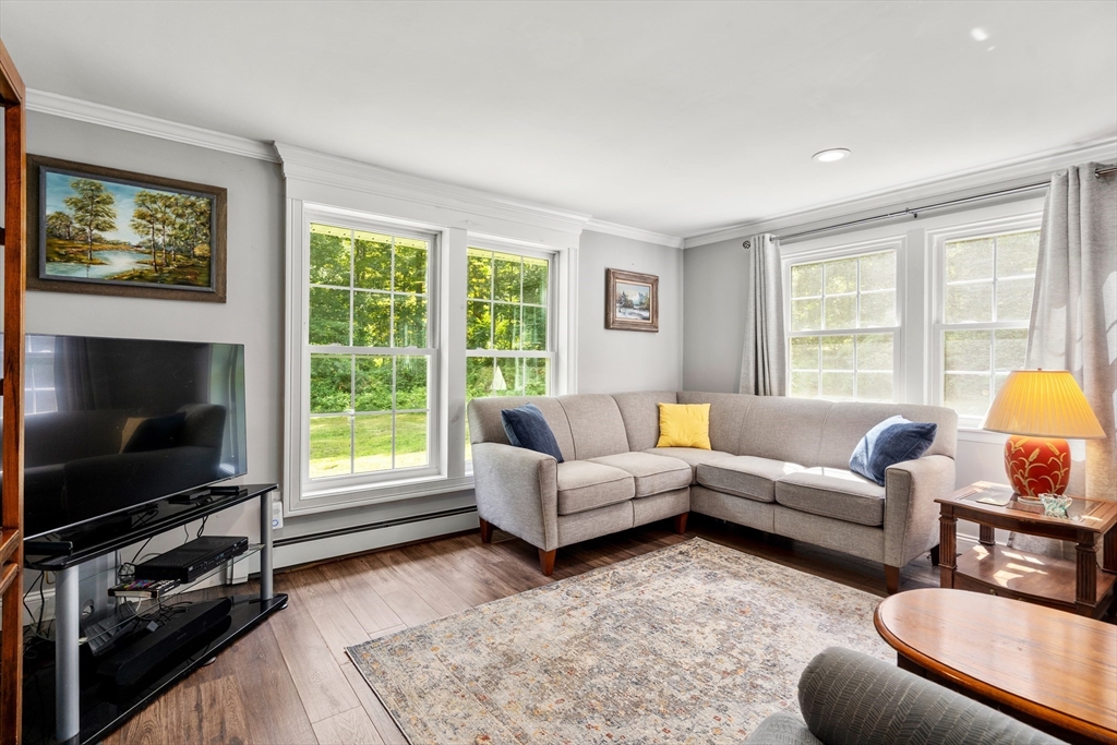 1 Sunset Rock Road Wilbraham, MA 01095 - Photo 12 of 24 a living room with furniture a flat screen tv and a floor to ceiling window