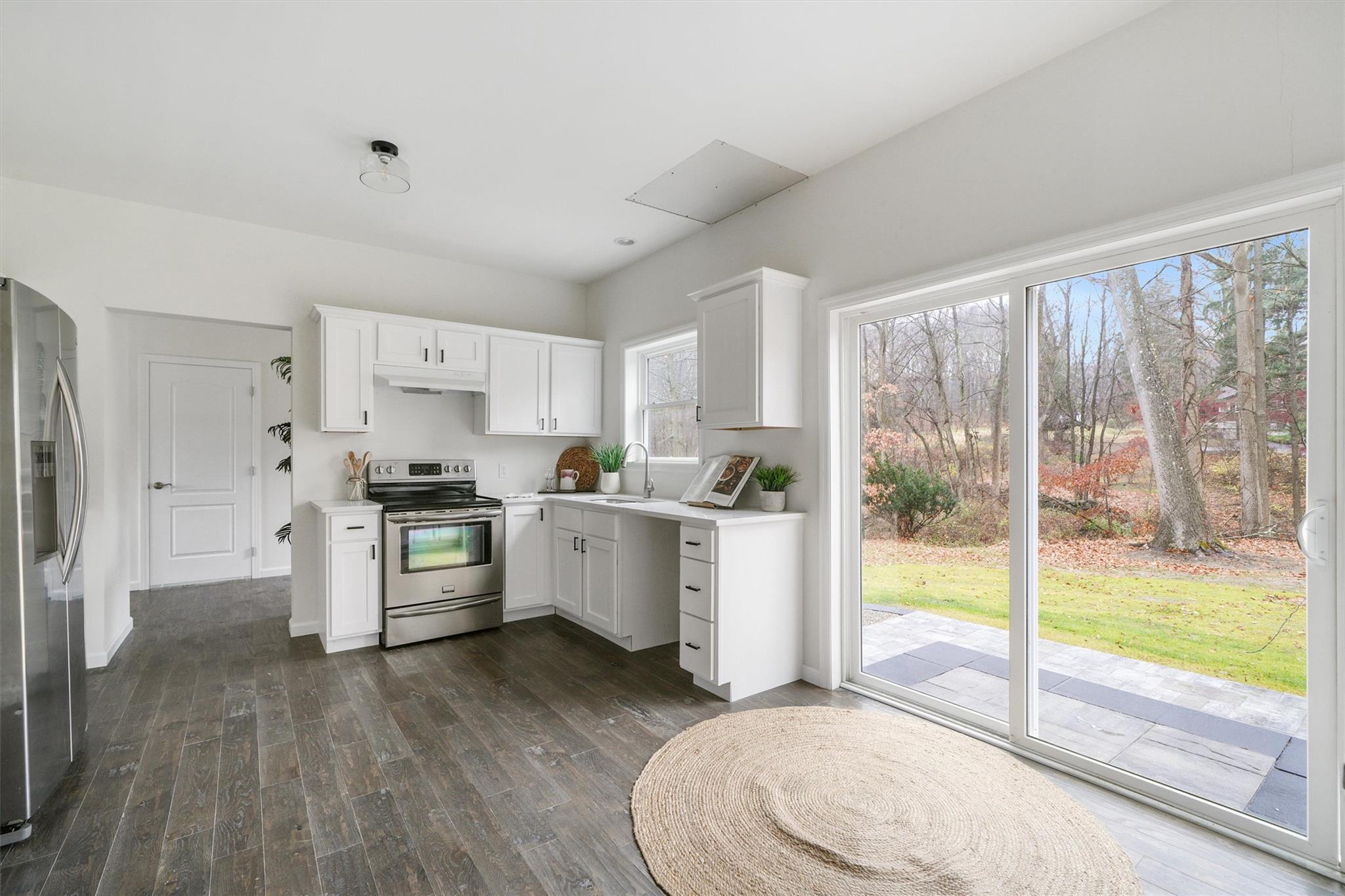 2685 Gregory Street Yorktown Heights, NY 10598 - Photo 13 of 35 Kitchen with appliances with stainless steel finishes, white cabinetry, and a wealth of natural light