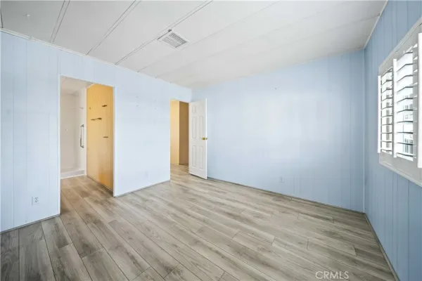 an empty room with windows and closet