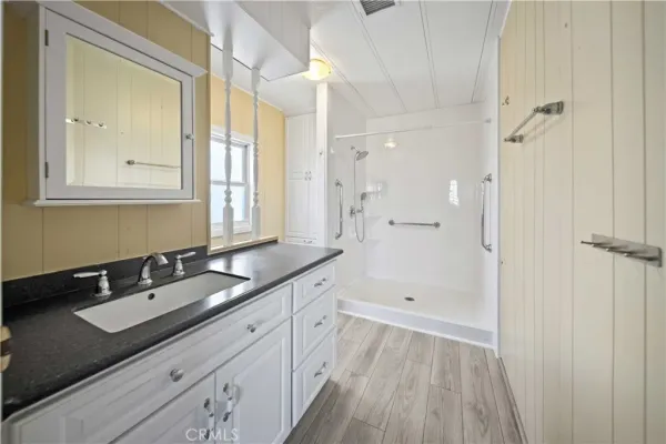 a spacious bathroom with a granite countertop sink mirror and shower