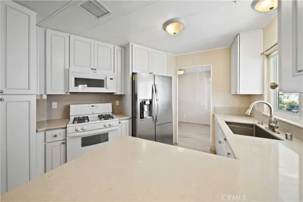 a kitchen with stainless steel appliances granite countertop a refrigerator sink and stove