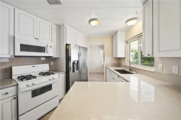 a kitchen with stainless steel appliances a refrigerator stove microwave and sink