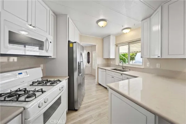 a kitchen with stainless steel appliances a stove a sink a refrigerator and cabinets