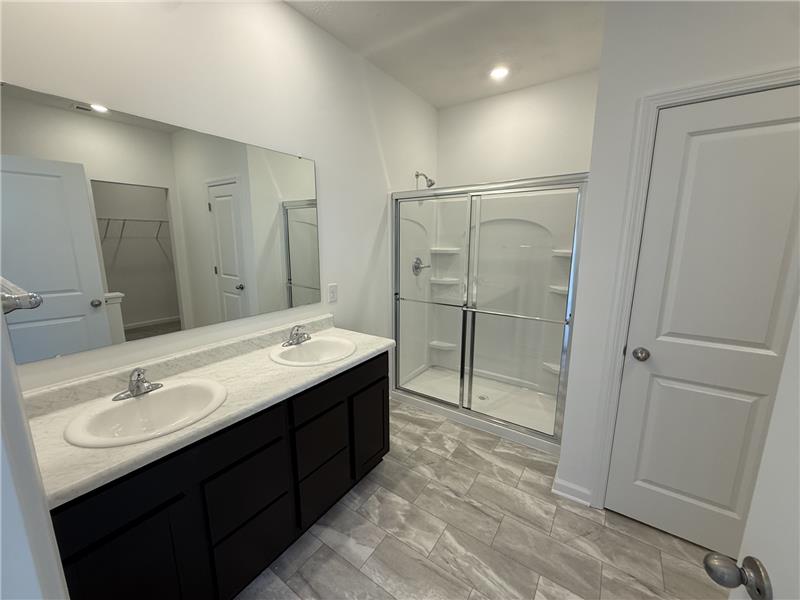 4001 Chakeres Avenue Springfield, OH 45505 - Photo 10 of 15 This spacious bathroom offers a double vanity and a glass-enclosed shower, perfect for daily routines.