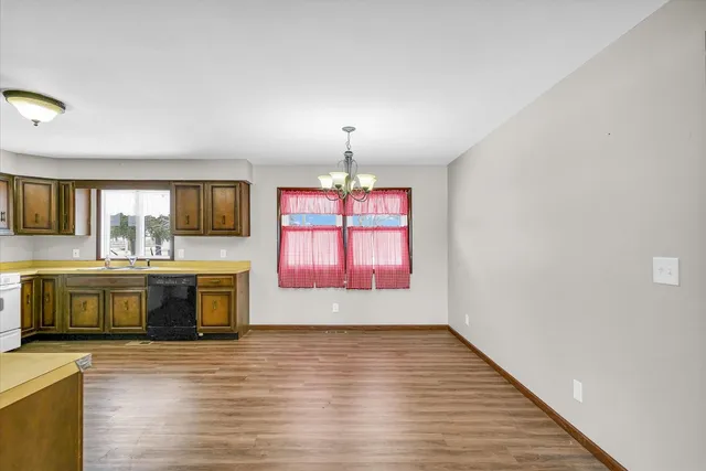 a view of living room with kitchen island granite countertop wooden floor and a large window