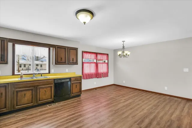a large kitchen with stainless steel appliances granite countertop a stove and a wooden floors