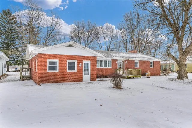a view of a house with a yard covered in snow