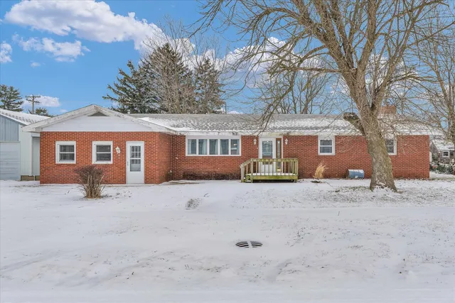 a view of a house with a yard covered in snow