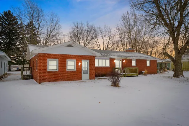 a view of a house with a yard covered in snow