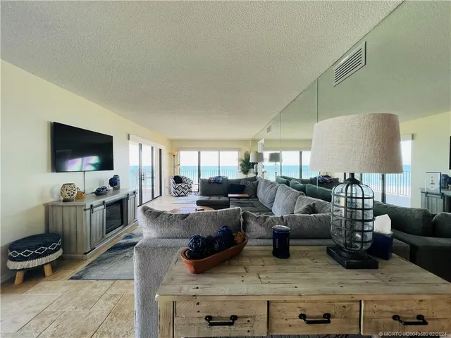 a living room with furniture and floor to ceiling windows