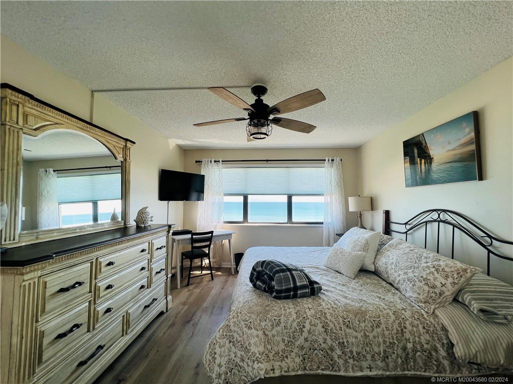 Undisclosed Address Jensen Beach, FL 34957 - Photo 45 of 86 a bedroom with a bed and a chandelier with a flat tv screen