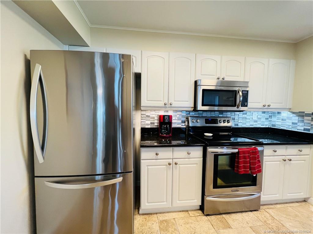 Undisclosed Address Jensen Beach, FL 34957 - Photo 8 of 86 a kitchen with stainless steel appliances granite countertop a refrigerator and a stove top oven