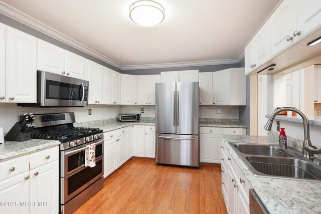 a kitchen with granite countertop a refrigerator stove top oven and sink