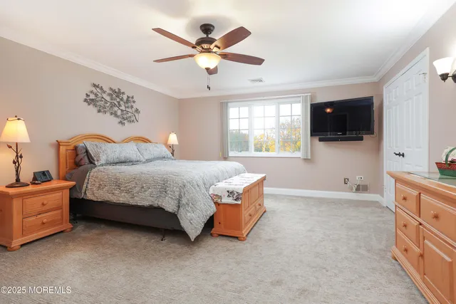 a bedroom with a large bed and ceiling fan