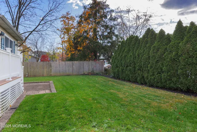 a view of a backyard with table and chairs and wooden fence
