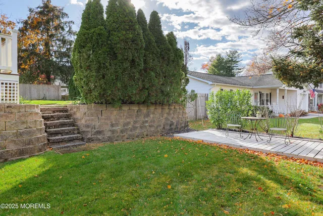 a view of a house with a yard and a wooden fence