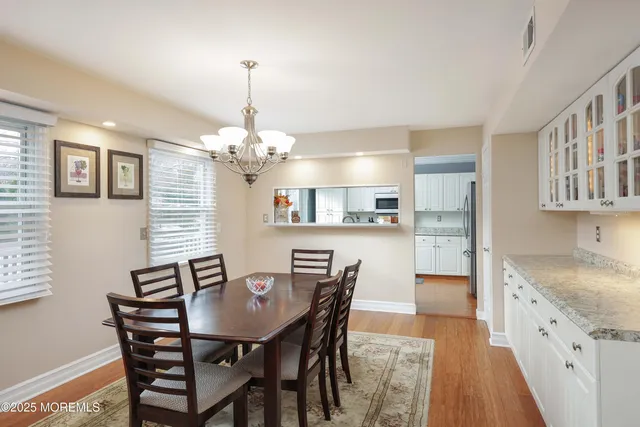 a view of a dining room with furniture a chandelier and wooden floor