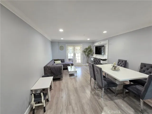 a living room with furniture a flat screen tv and a table