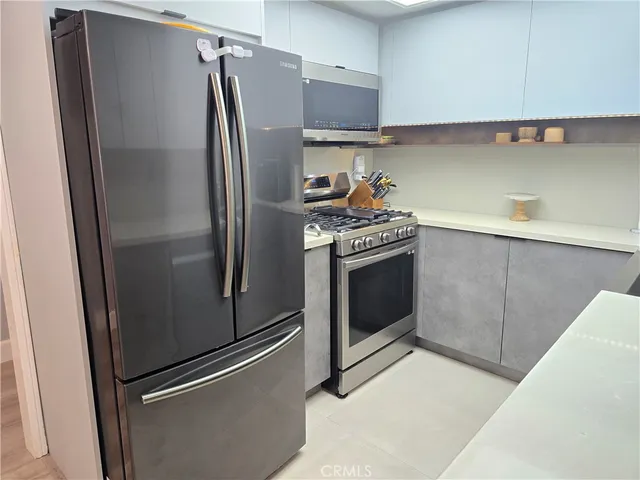 a metallic refrigerator freezer sitting in a kitchen