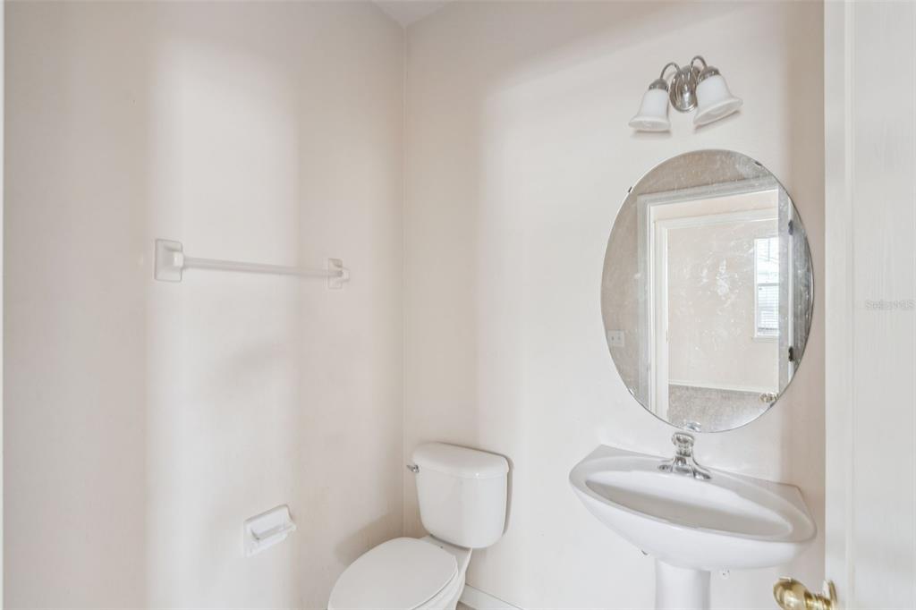 1755 Royal Ridge Drive Davenport, FL 33896 - Photo 14 of 25 a bathroom with a toilet a sink and mirror