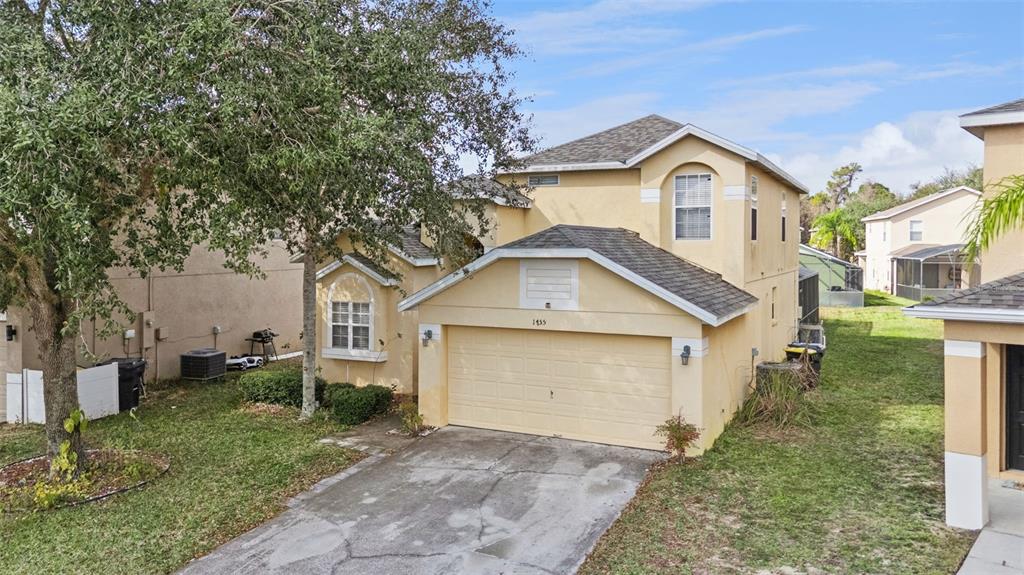 1755 Royal Ridge Drive Davenport, FL 33896 - Photo 20 of 25 a front view of a house with a yard and garage