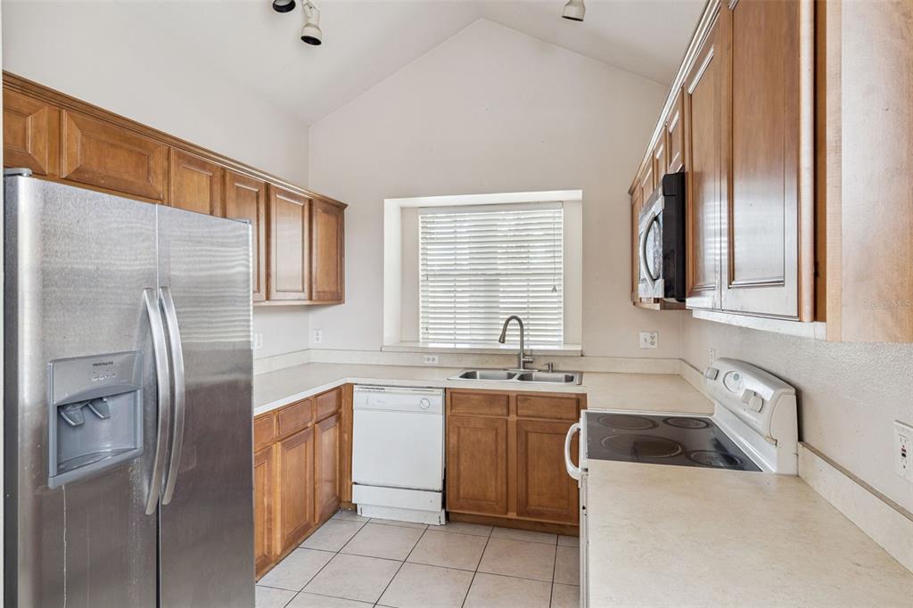1755 Royal Ridge Drive Davenport, FL 33896 - Photo 5 of 25 a kitchen with stainless steel appliances a refrigerator sink and cabinets