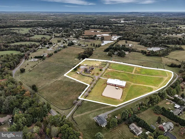 an aerial view of a tennis ground and a cars park side of the road
