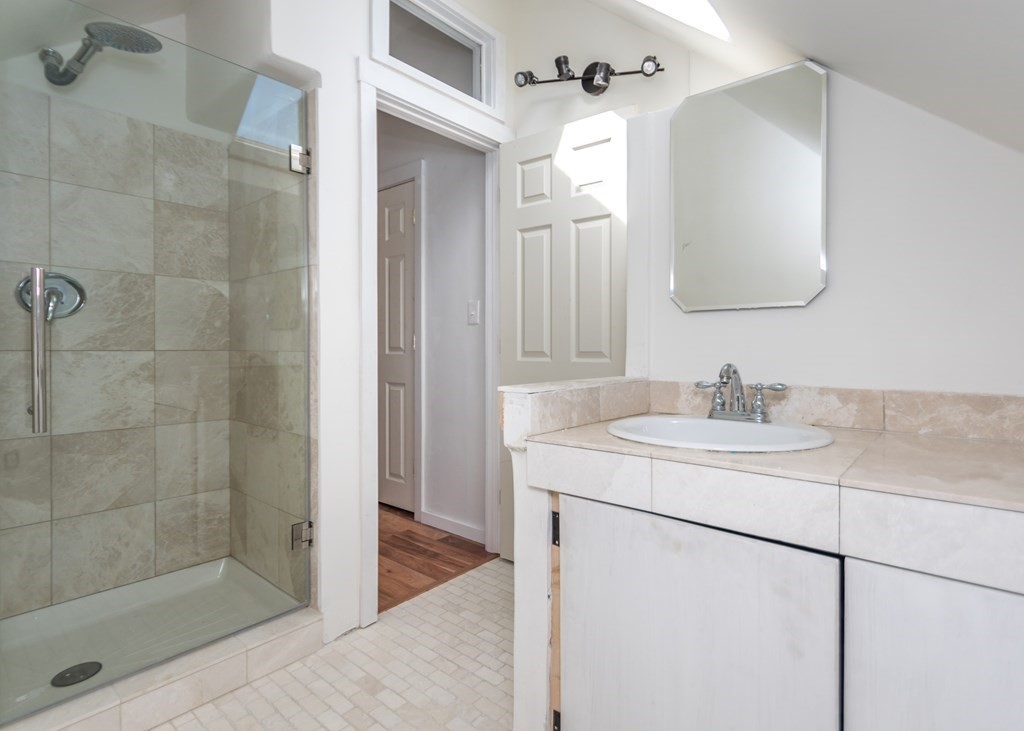16 Hamblin Road, Unit 2 Waltham, MA 02453 - Photo 23 of 29 a bathroom with a granite countertop sink a mirror and shower