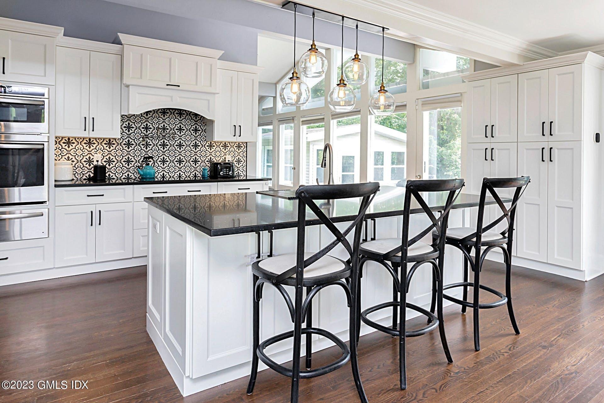 396 Westover Road Stamford, CT 06902 - Photo 13 of 39 a kitchen with stainless steel appliances granite countertop a table chairs and wooden cabinets