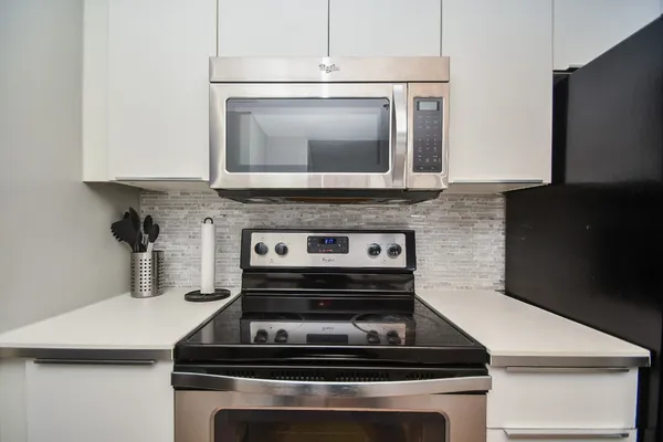 a kitchen with granite countertop a refrigerator stove and microwave
