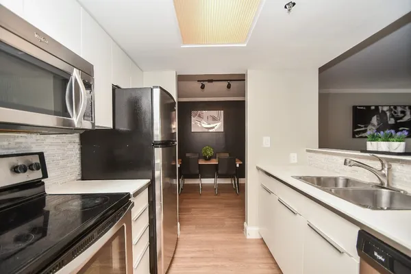 a bedroom with a large bed and a flat tv screen on dresser