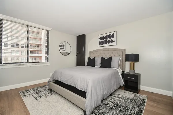 a bedroom with a bed and a painting on the wall