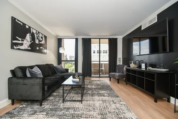 a living room with furniture and a wooden floor
