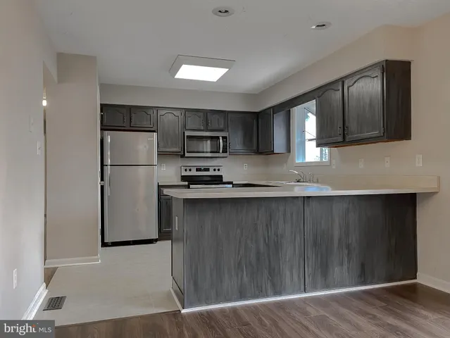 a kitchen with stainless steel appliances a refrigerator and a stove top oven