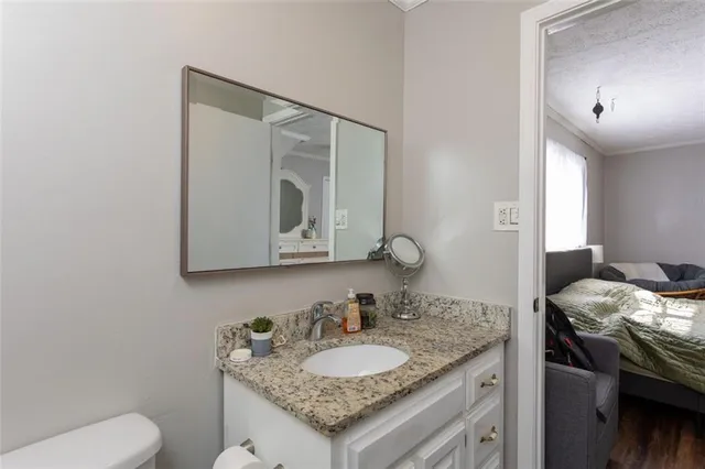 a bathroom with a granite countertop sink and a mirror