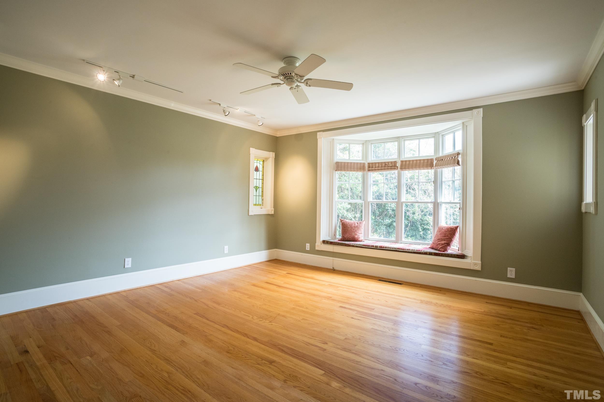 1903 Alexander Road Raleigh, NC 27608 - Photo 15 of 26 an empty room with wooden floor fan and windows